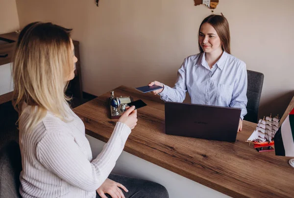 Female travel agent giving tickets to young happy couple.