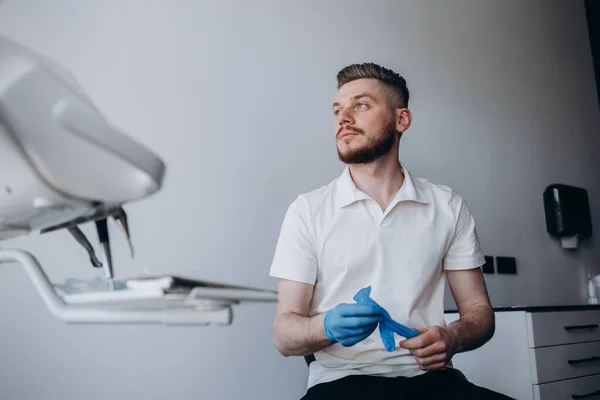 Mężczyzna Dentysta Zakładając Rękawiczki Pracy Pacjentami — Zdjęcie stockowe