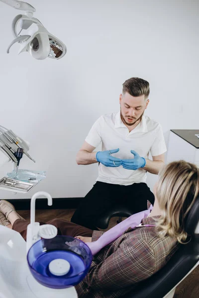 Dentysta Masce Okularach Leczący Pacjentkę Blondynkę Trzymający Narzędzia Dentystyczne Noszący — Zdjęcie stockowe