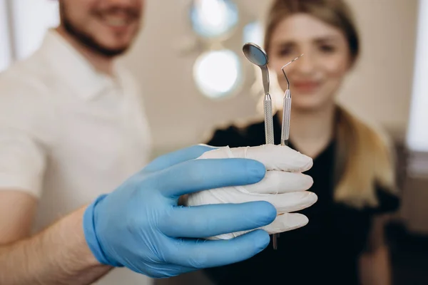 Close up of dentist\'s hands holding dental tools.