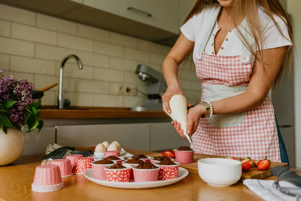 赤いビロードのカップケーキを作るのアクション 女性手配管クリーム チーズ ケーキに — ストック写真