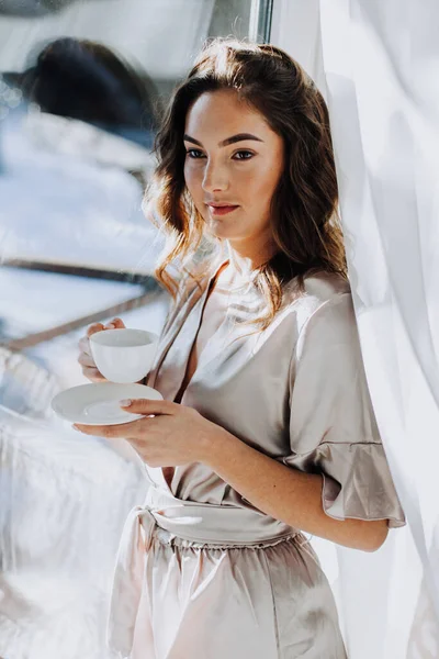 Genç kadın evde pencere bir sabah kahve içme