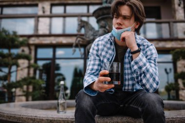 Bir adam koronavirüs salgını yüzünden karantina sırasında alkol tüketiyor.