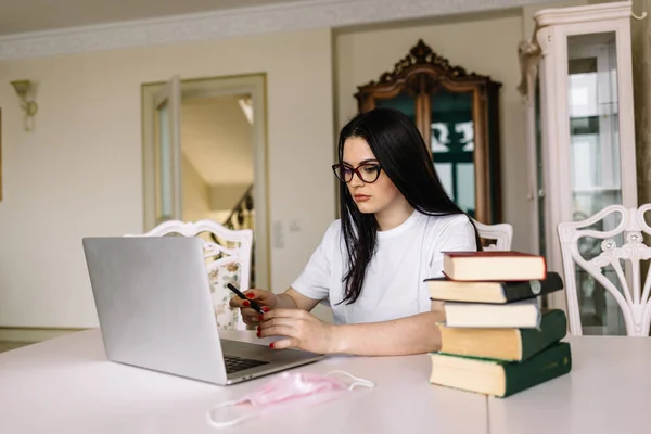 Pretty student with laptop and books quarantining from home