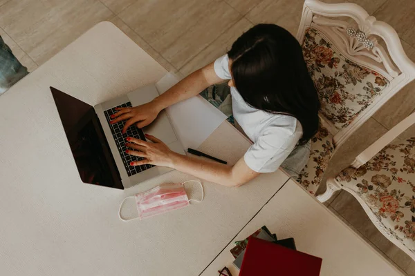 Top view of young woman sitting on floor with laptop