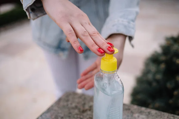 Female hands using hand sanitizer gel pump dispenser