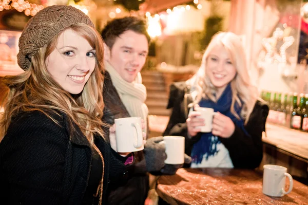 Unga dricker punch på julmarknad — Stockfoto