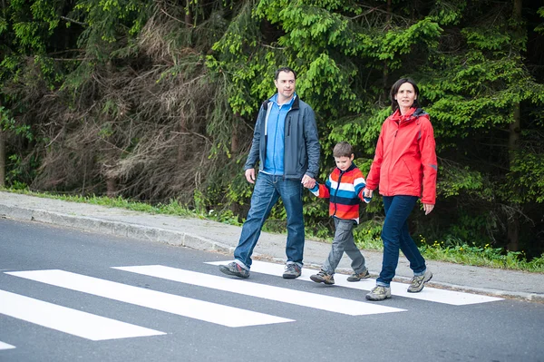 Familie überquert die Straße Stockbild