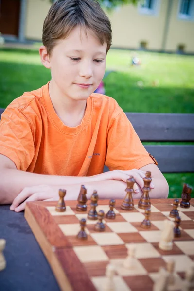 Pojke spela schack med koncentration — Stockfoto