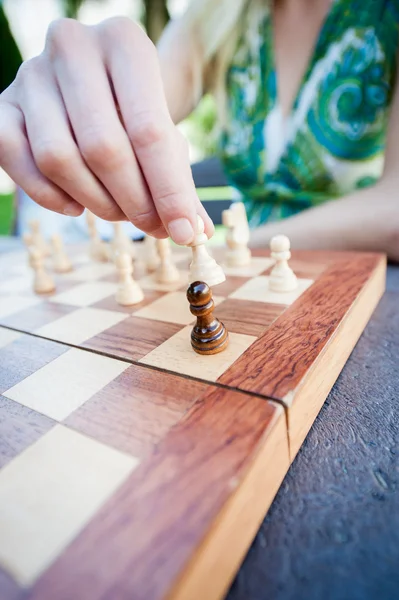 Woman moves piece in chess — Stock Photo, Image