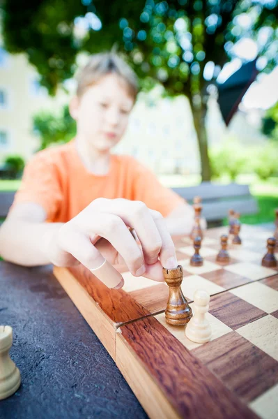Boy moves piece in chess — Stock Photo, Image