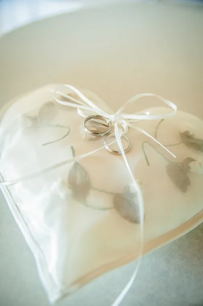 Coração em forma de almofada com anéis de casamento — Fotografia de Stock