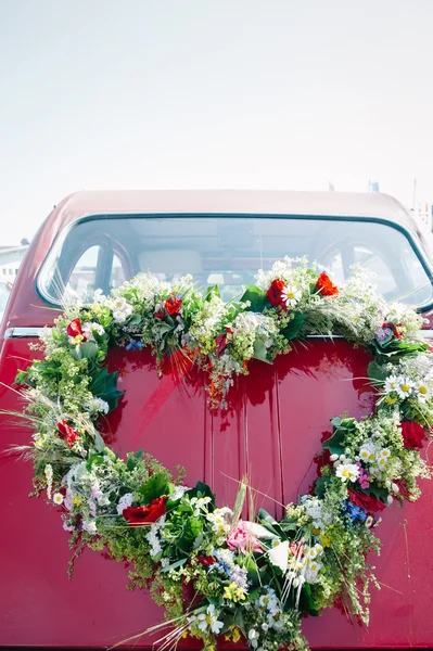 Bouquet on a red wedding car — Stock Photo, Image