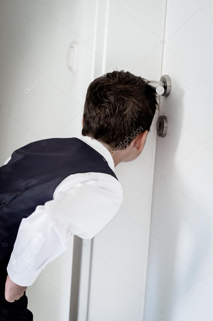 Boy looking through a keyhole