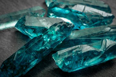 Aquamarines ve ham kristal mücevher konsepti bir demet mavi kesilmemiş akuamarin, topaz veya turmalin kristallerine yakın çekim