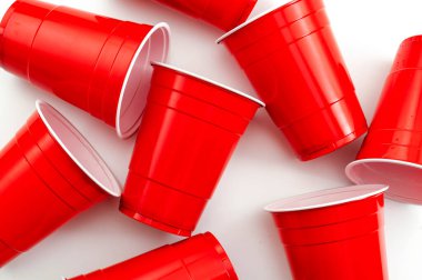 Üniversite partisi ve bira pong konsepti. Kırmızı, beyaz arka planda plastik bardaklar.