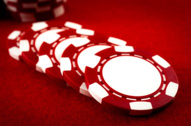 Kumar ve şans oyunlarına olan bağımlılık ve yakın plan poker fişleri arka planda desteler ve ön çipteki yazı için fotokopi alanı ile kırmızı keçeli kalemlerin üzerine serpiştirilmiş.