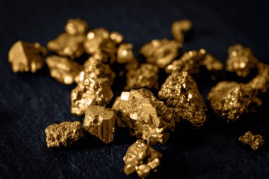 Altın madenciliği ve değerli metal konseptine yapılan yatırım siyah arka planda altın külçeleri yakından takip ediyor.