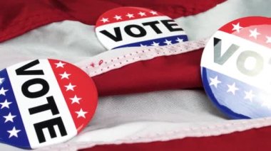 4k panning footage of Vote buttons and democrat and republican pin on the USA flag concept for election in United states of America, voting in American democracy, party politics and political campaign