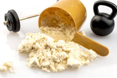 Scoop filled with protein powder, barbell and kettlebell isolated on white background, concept for intense resistance training technique, progressive weight overload and complete sports nutrition
