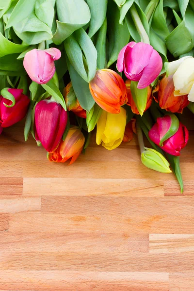 Spring tulips on wooden table — Stock Photo, Image