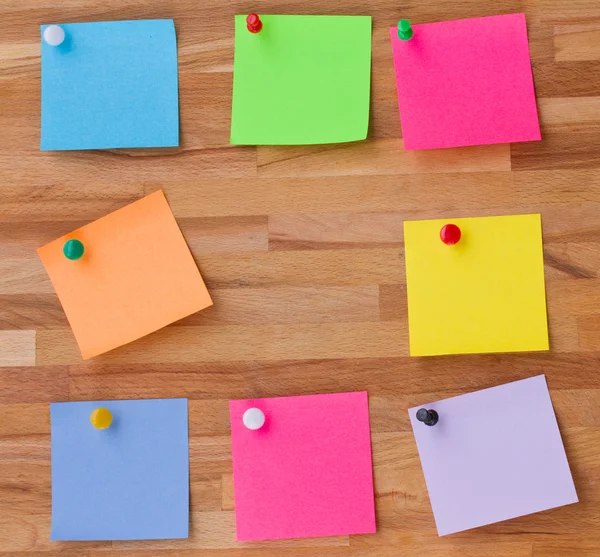 Hojas coloridas de papel sobre tabla de madera — Foto de Stock