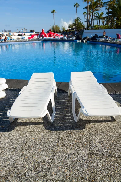 Swimming pool surrounded by chairs — Stock Photo, Image