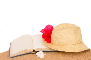 Hasır şapka ans kitap kum üzerinde