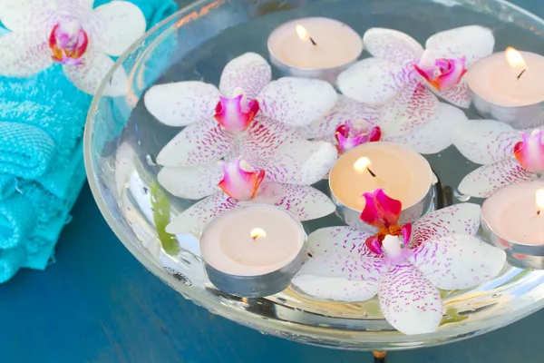 Brennende Kerzen und rosa Orchideenblumen aus nächster Nähe — Stockfoto