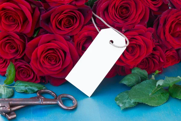 Crimson roses with empty tag — Stock Photo, Image