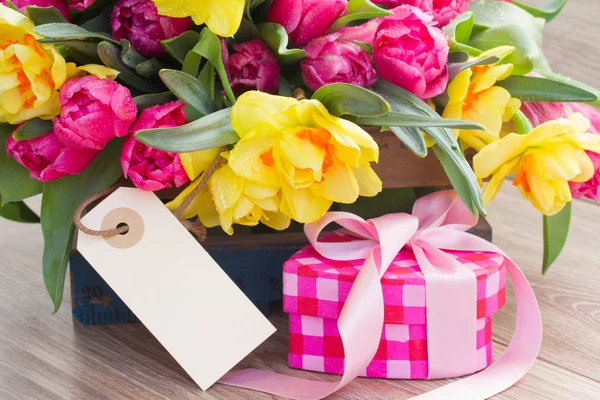 Flores da primavera com caixa de presente e etiqueta vazia — Fotografia de Stock