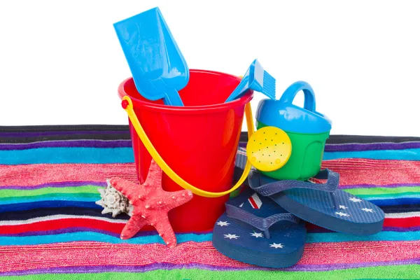 Пляжные игрушки с шлепанцами и морской звездой на полотенце — стоковое фото