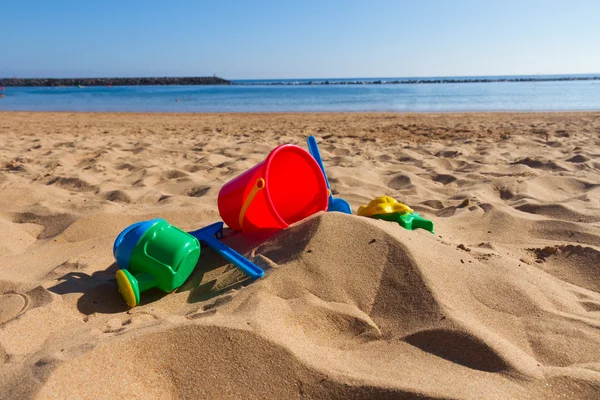 Giocattoli da spiaggia in sabbia sulla riva del mare — Foto Stock
