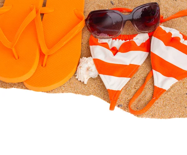 Orangefarbene Sandalen und Schwimmsiut auf Sand — Stockfoto