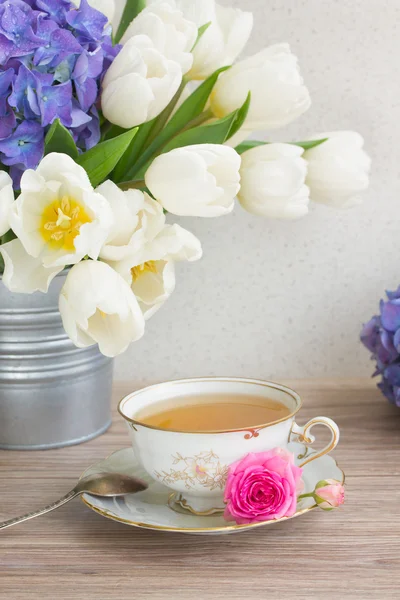 Antique cup of tea with tulips — Stock Photo, Image