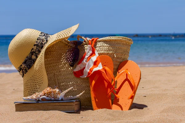 Opalování příslušenství na písečné pláži v slaměné tašky — Stock fotografie