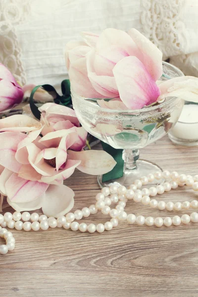 Άνθη μανόλιας με μαργαριτάρια σε ξύλινο τραπέζι — Φωτογραφία Αρχείου