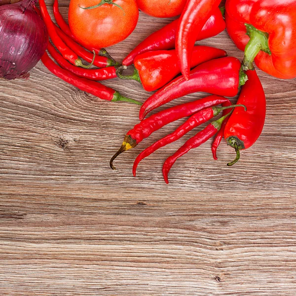 Red peppers on wooden table — Stock Photo, Image