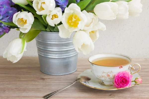 Vintage cup of tea with tulips — Stock Photo, Image