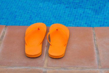 havuz kenarında turuncu flip flop