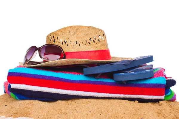 Sunbathing accessories and straw hat on sand — Stock Photo, Image