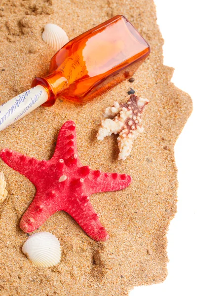 Starfish and bottle with letter on sand — Stock Photo, Image