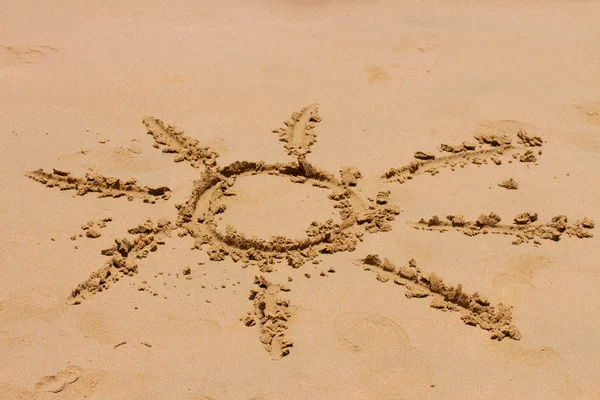Знак солнца на песке — стоковое фото