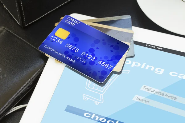Pila de tarjetas de crédito con tienda virtual en pantalla — Foto de Stock