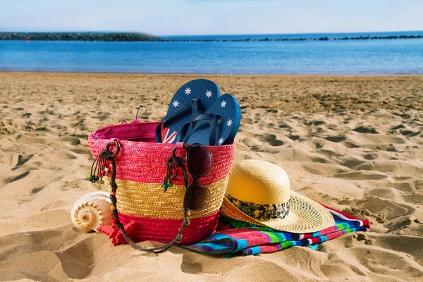 Sunbathing accessories on sandy beach — Stock Photo, Image