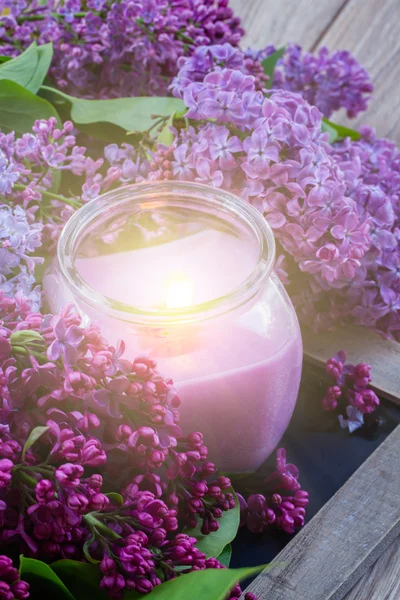 Flores de color lila con vela — Foto de Stock