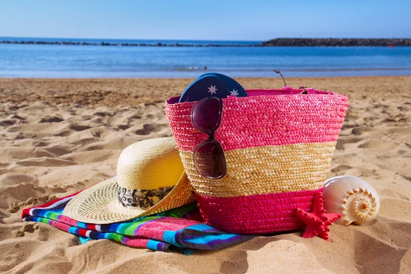 Bolsa strwa con accesorios para tomar el sol en la playa de arena —  Fotos de Stock