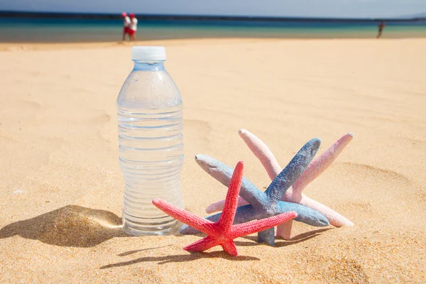 Bottiglia d'acqua sulla spiaggia di sabbia — Foto Stock