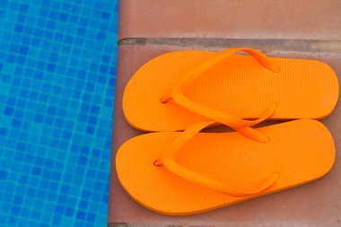 havuz kenarında turuncu flip flop