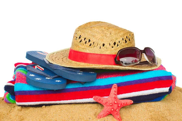 Accessori per prendere il sole e cappello di paglia sulla sabbia — Foto Stock